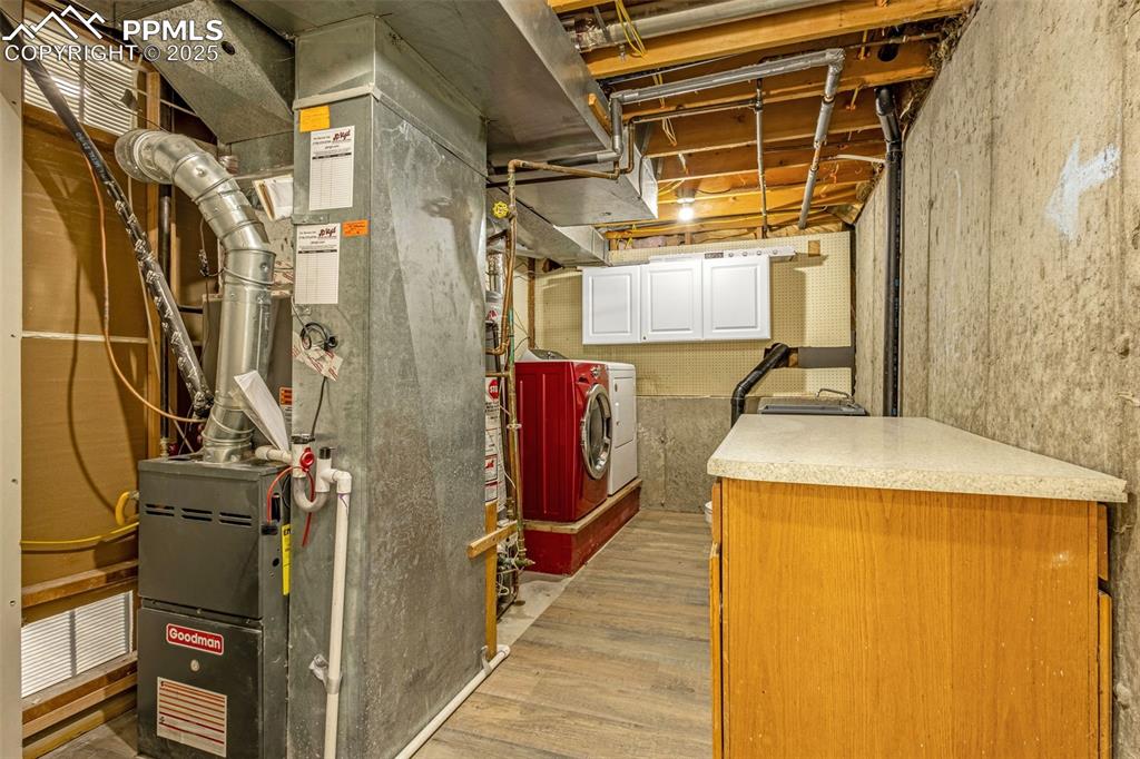 Image 29 of 36: Unfinished below grade area with washing machine and dryer, heating unit, a