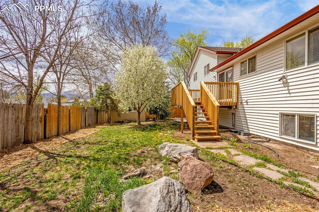 Image 34 of 36: View of yard featuring a wooden deck, stairway, and a fenced backyard