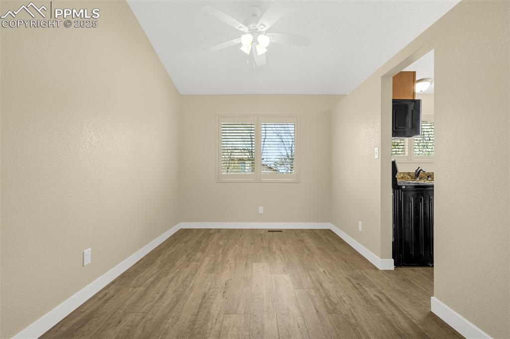 Image 7 of 36: Spare room with baseboards, wood finished floors, ceiling fan, and plenty o