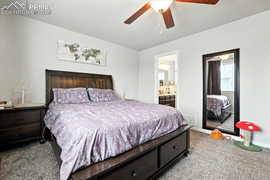 Image 12 of 31: Bedroom with carpet flooring, connected bathroom, and ceiling fan