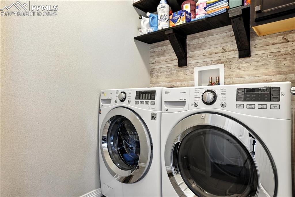 Image 20 of 31: Laundry room featuring washing machine and dryer, a textured wall, and wood