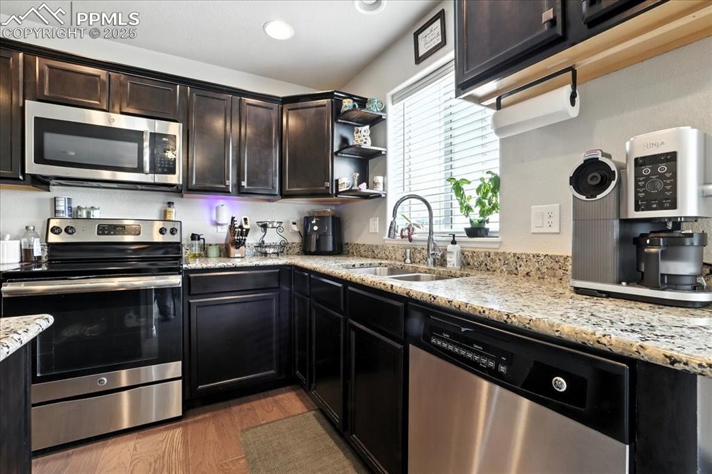 Image 4 of 31: Kitchen with appliances with stainless steel finishes, light wood-style flo