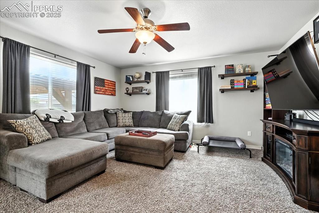 Image 5 of 31: Living room featuring light colored carpet, a textured ceiling, and a ceili
