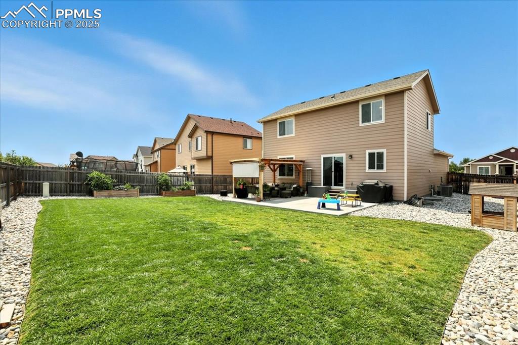 Image 6 of 31: Back of house with a fenced backyard, a patio, and a residential view