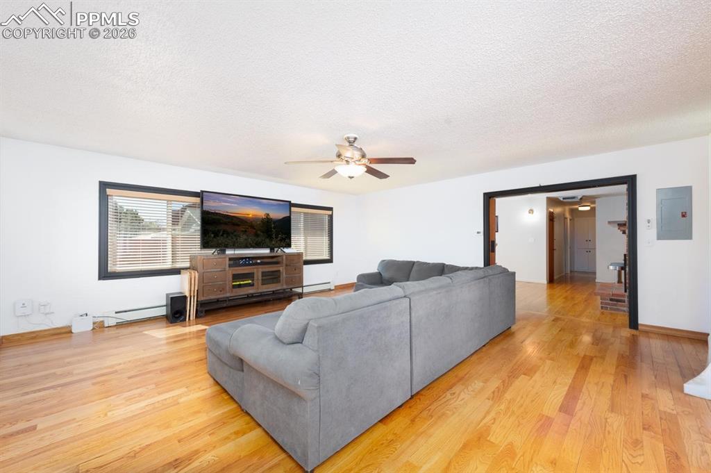 Image 13 of 34: The living room is located off of the dining room. It features large window