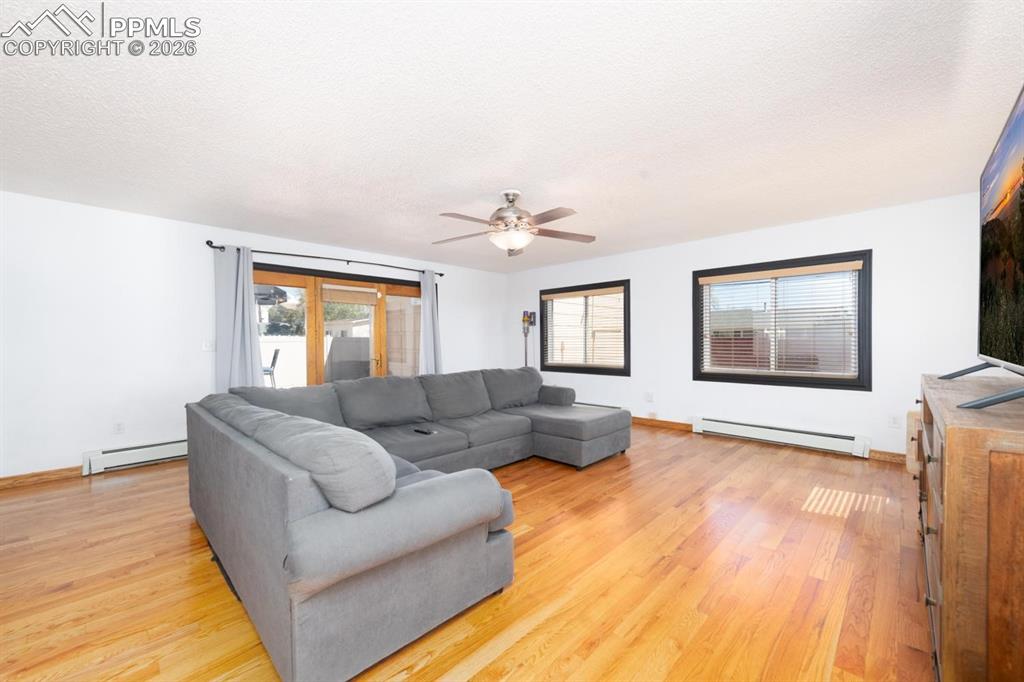 Image 14 of 34: The living room is located off of the dining room. It features large window