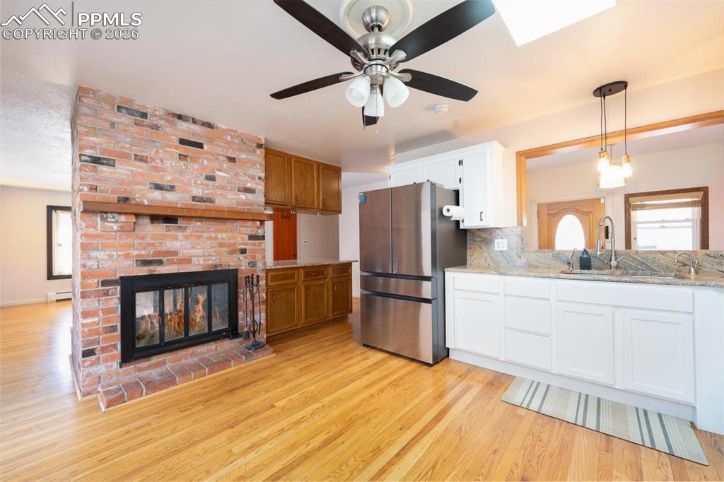 Image 6 of 34: Kitchen with double sided fireplace and a sliding glass door that leads to