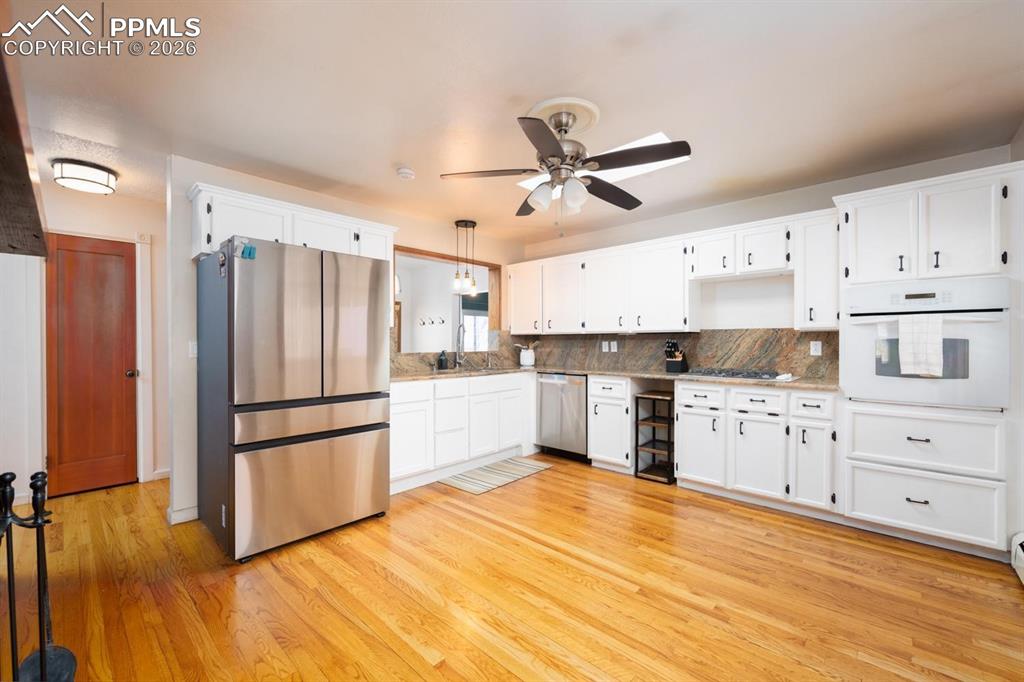 Image 7 of 34: Kitchen with double sided fireplace and a sliding glass door that leads to
