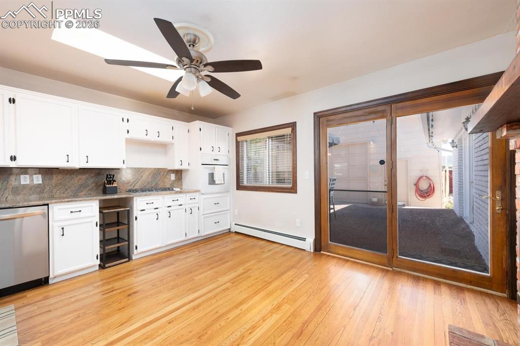 Image 8 of 34: Kitchen with double sided fireplace and a sliding glass door that leads to