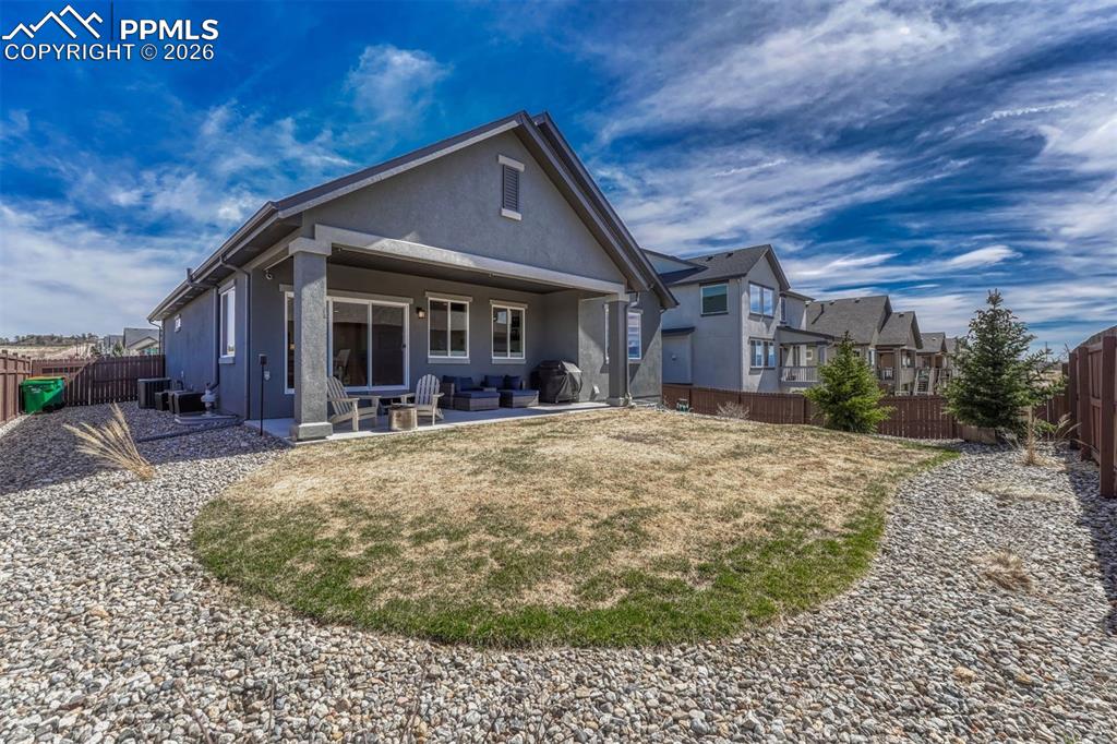 Image 12 of 46: Covered patio with custom shades for year-round comfort