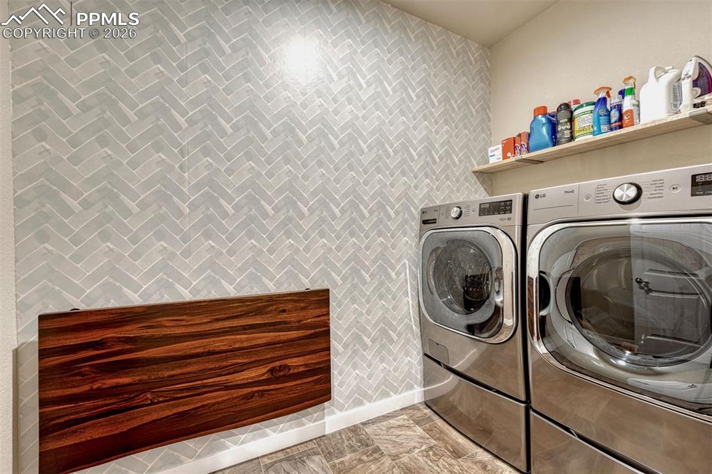 Image 35 of 46: Stylish main level laundry with custom fold out table.