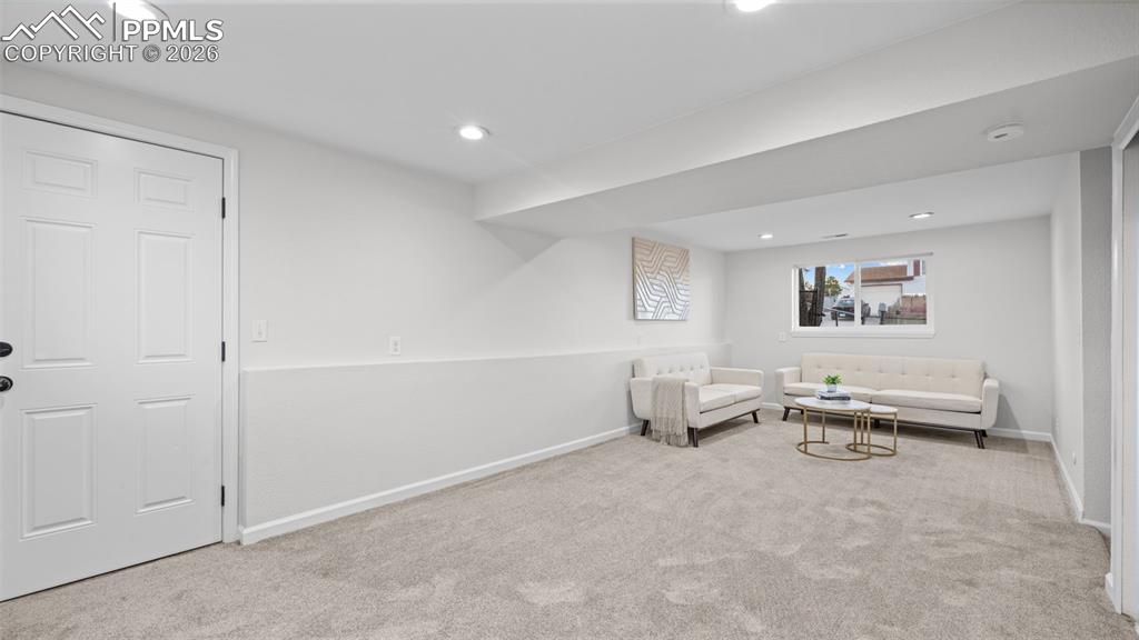 Image 20 of 38: Living area featuring light colored carpet and recessed lighting