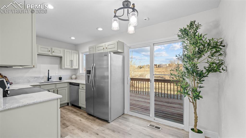 Image 7 of 38: Kitchen with stainless steel appliances, light wood-style flooring, light s