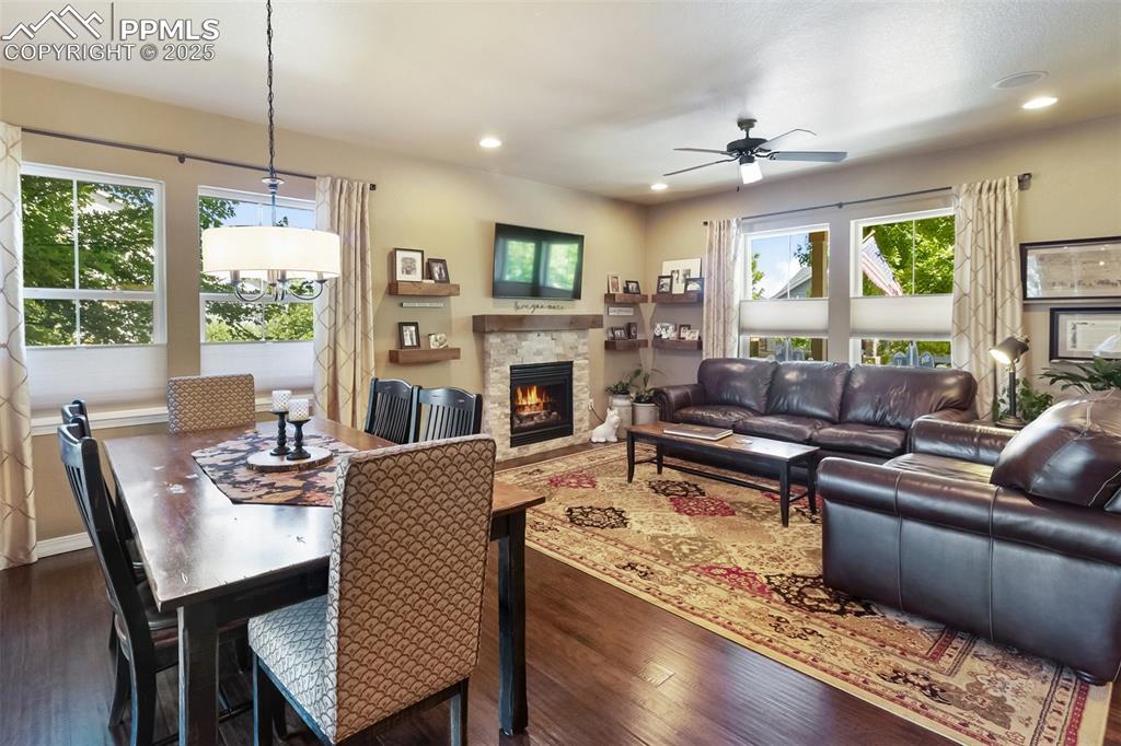 Image 11 of 50: Dining room with plenty of natural light, a ceiling fan, dark wood-style fl