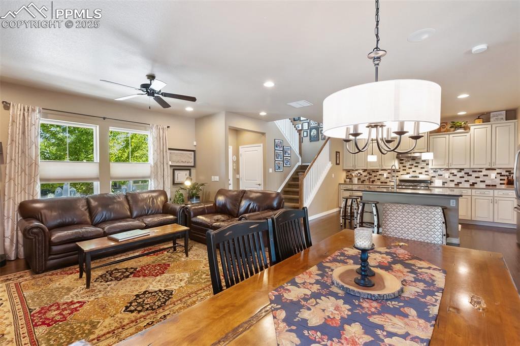 Image 15 of 50: Living area featuring wood finished floors, a ceiling fan, stairs, recessed