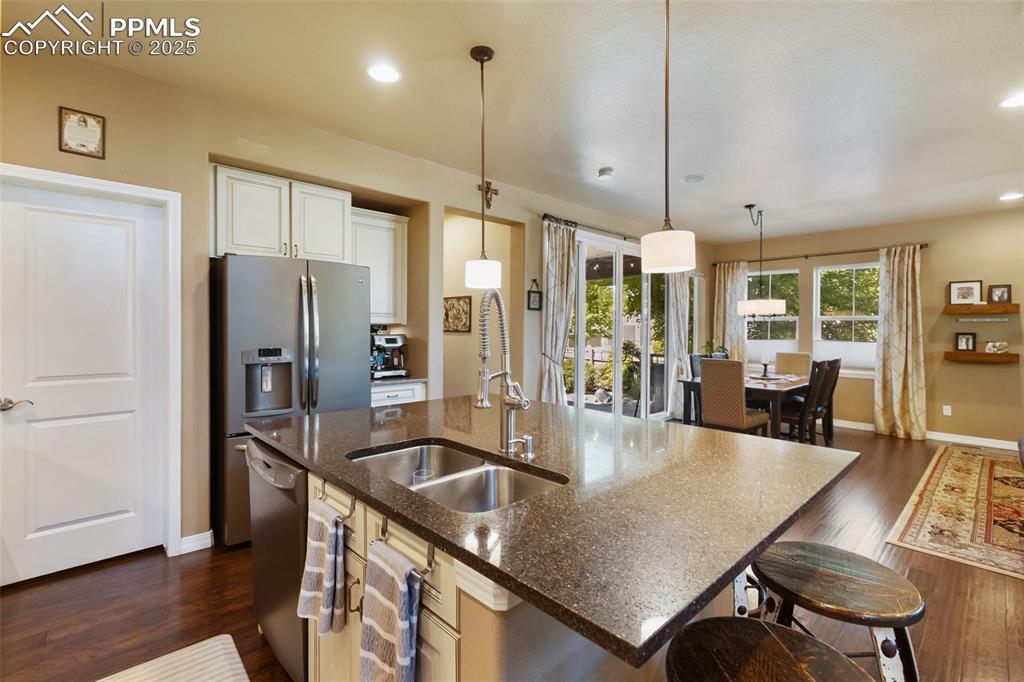 Image 18 of 50: Kitchen featuring appliances with stainless steel finishes, dark wood finis