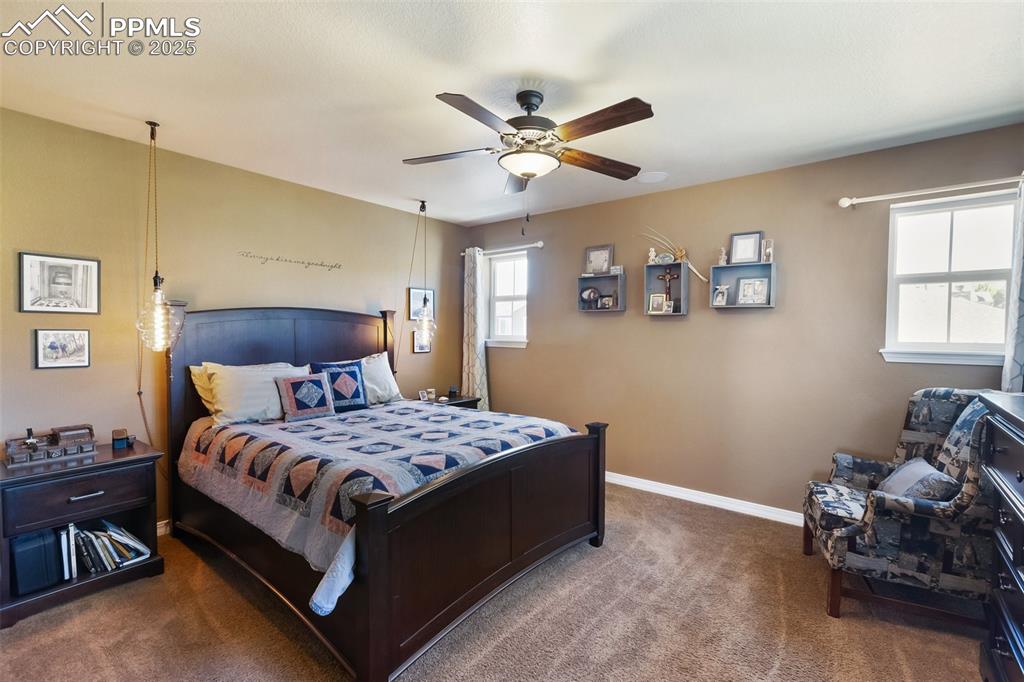 Image 25 of 50: Carpeted bedroom with baseboards and a ceiling fan