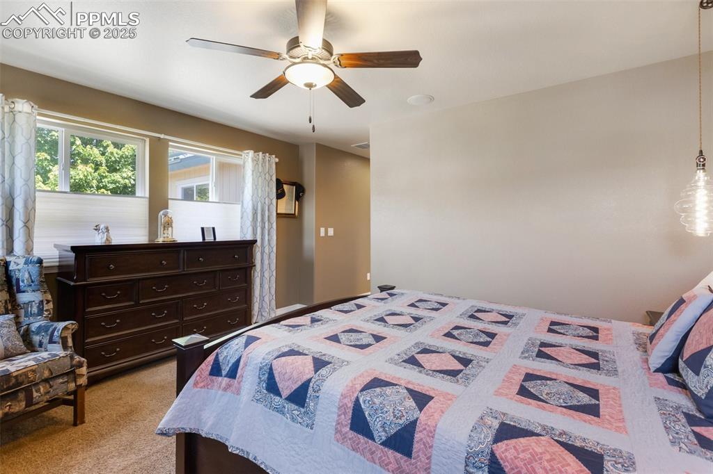 Image 27 of 50: Bedroom with ceiling fan and light colored carpet