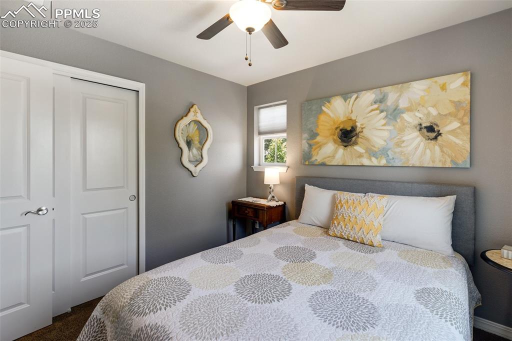 Image 30 of 50: Bedroom featuring dark colored carpet, ceiling fan, and a closet