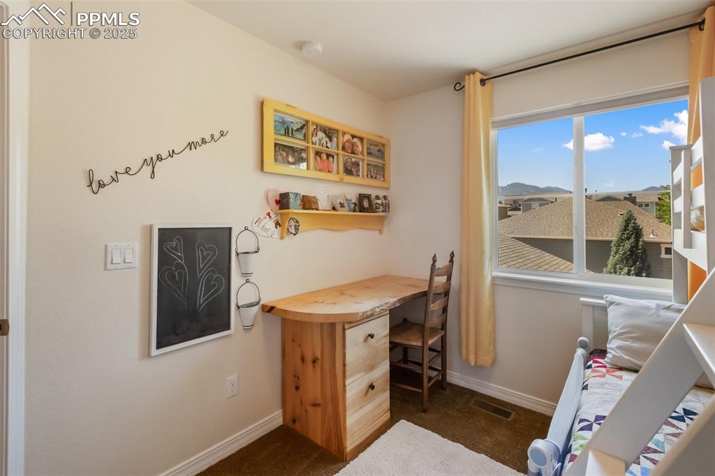 Image 33 of 50: Home office with dark colored carpet and baseboards
