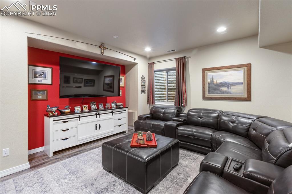 Image 36 of 50: Living area featuring wood finished floors and recessed lighting