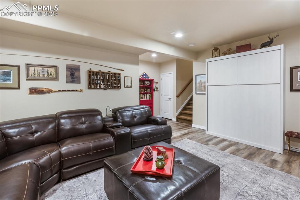 Image 37 of 50: Living room with stairway, wood finished floors, and recessed lighting