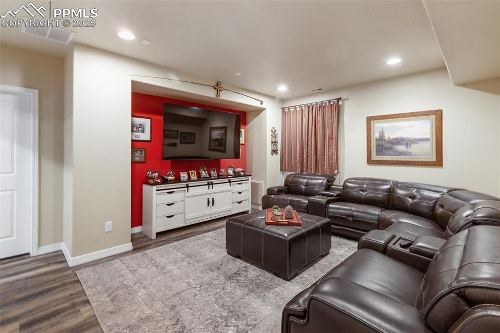 Image 39 of 50: Living area with wood finished floors and recessed lighting