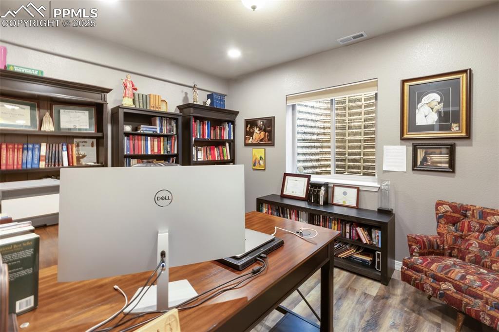 Image 41 of 50: Office area with wood finished floors and baseboards