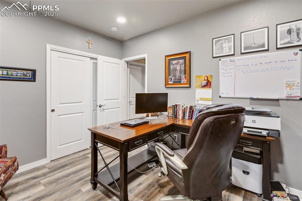 Image 42 of 50: Office with wood finished floors and baseboards