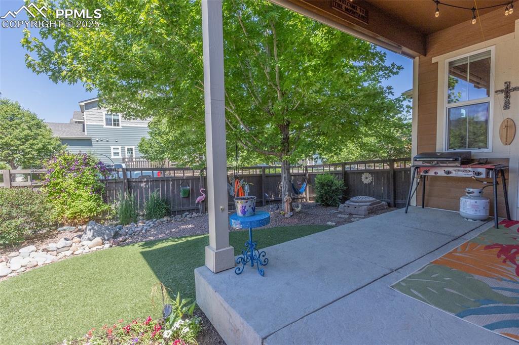 Image 43 of 50: Fenced backyard with a patio area