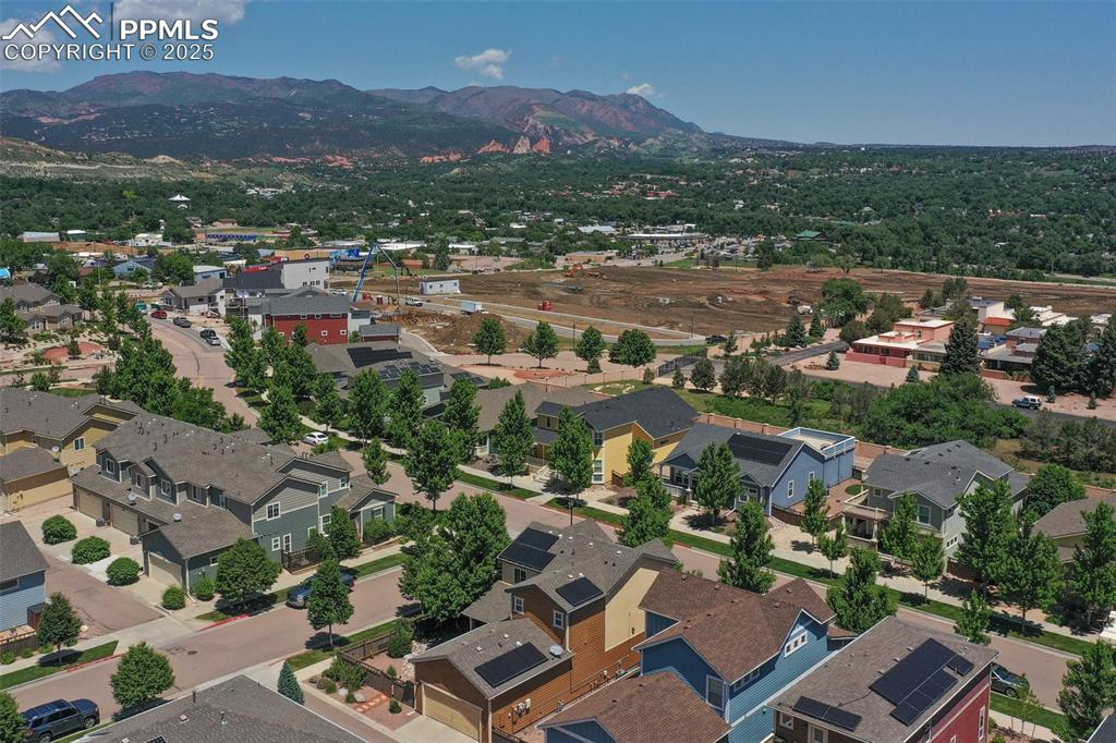 Image 47 of 50: Aerial view of residential area featuring a mountain backdrop