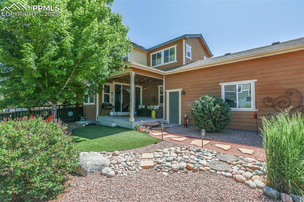 Image 7 of 50: Back of house featuring a patio and roof with shingles