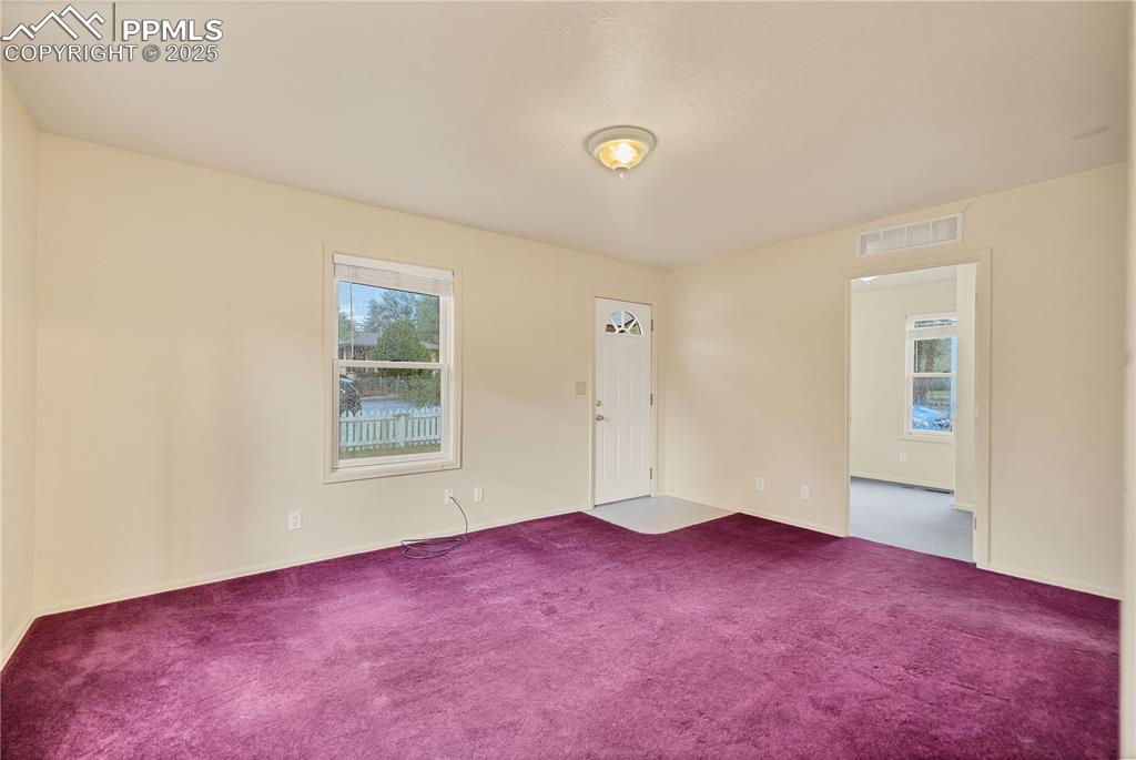 Image 12 of 16: Spare room with healthy amount of natural light and carpet