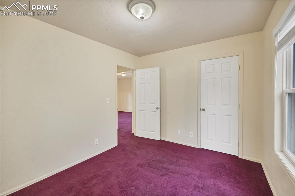 Image 13 of 16: Unfurnished bedroom with carpet flooring and multiple windows