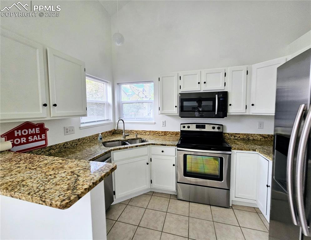 Image 15 of 31: Kitchen featuring appliances with stainless steel finishes, white cabinets,