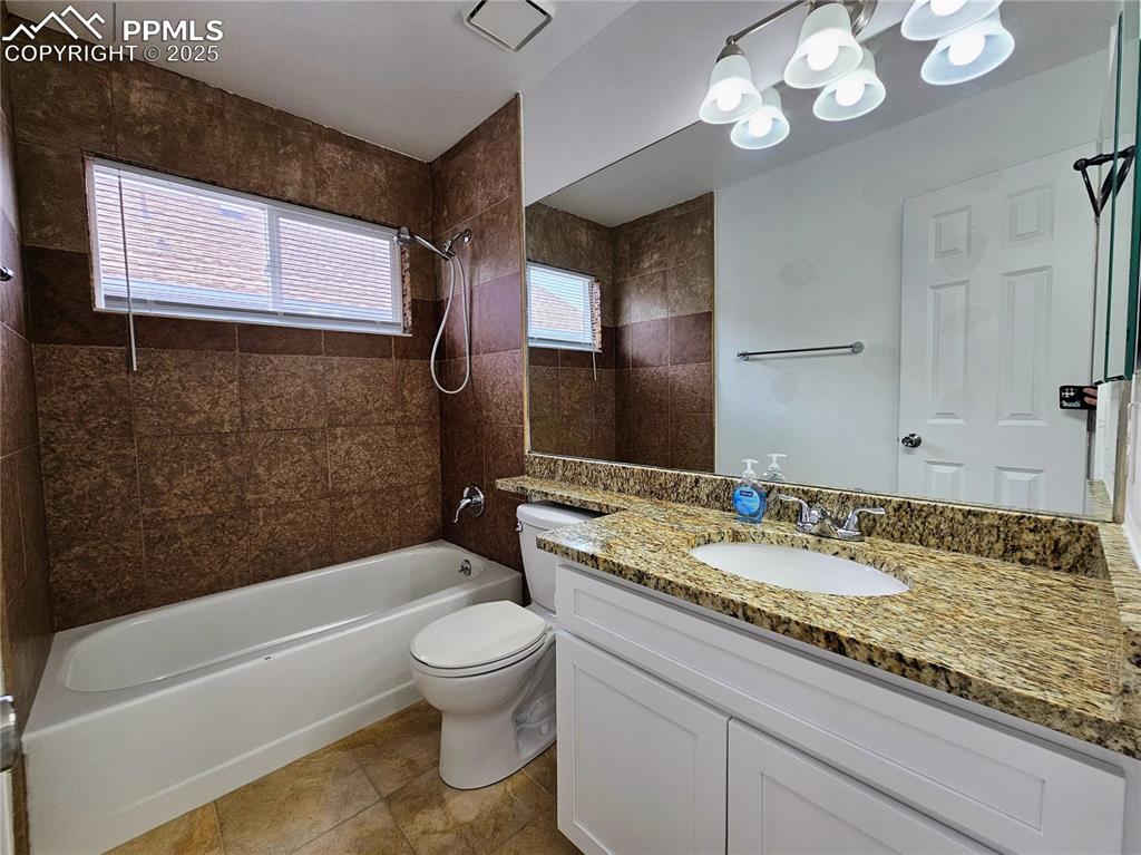 Image 24 of 31: Bathroom with bathing tub / shower combination, vanity, and light tile patt