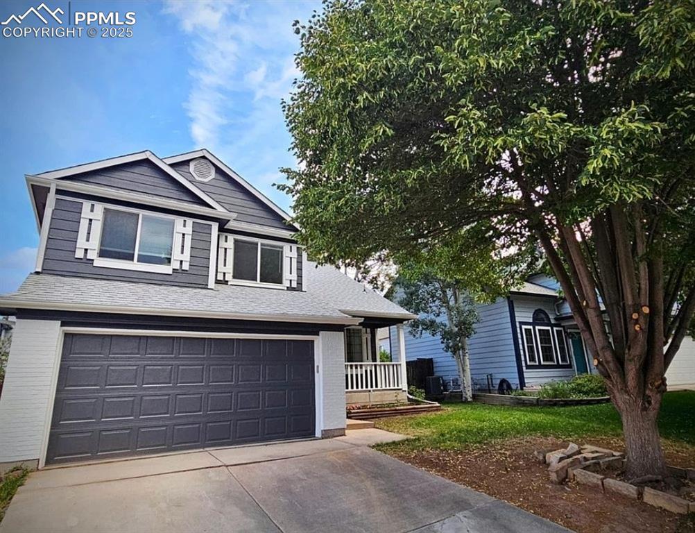 Image 31 of 31: View of front of house with driveway, a garage, a porch, and a front lawn