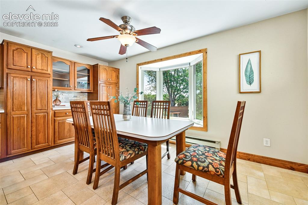 Image 11 of 50: Dining area has custom table that matches countertops, bay window with wind