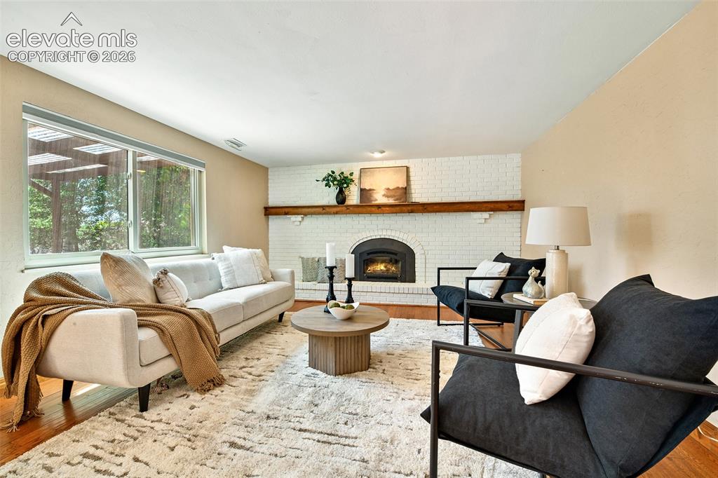 Image 12 of 50: Lower level family room with brick accent wall with gas fireplace and custo