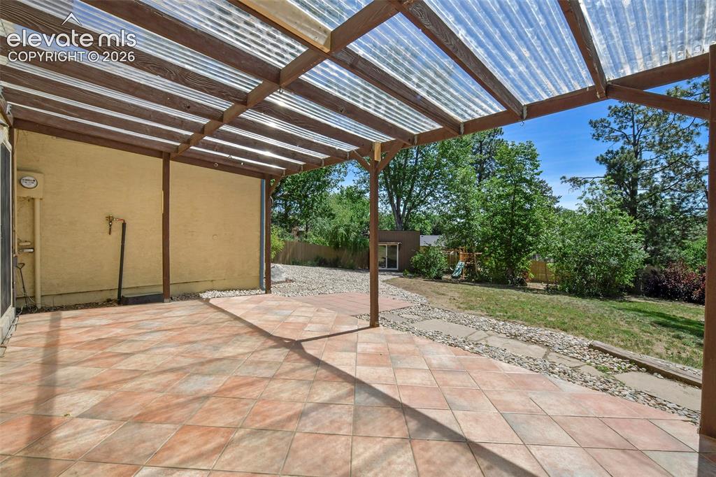 Image 15 of 50: Covered Tile Patio overlooking beautiful backyard