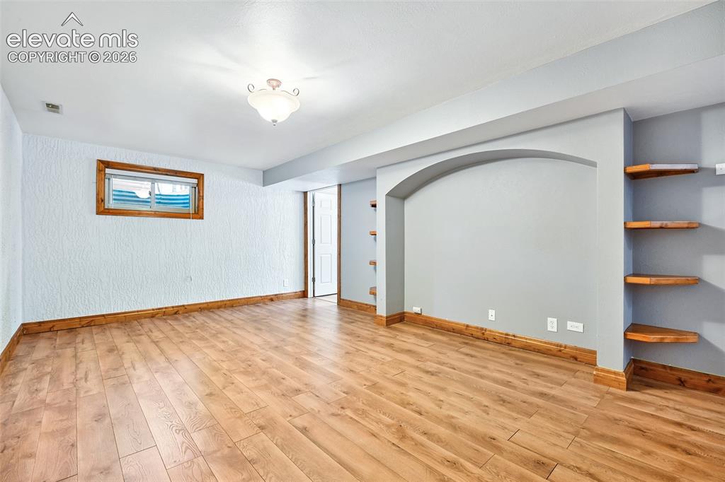 Image 28 of 50: Large Rec Room in basement with built in shelves