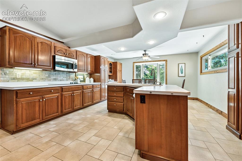 Image 9 of 50: Tile backsplash, varied plank tile floor, two pullout cutting boards