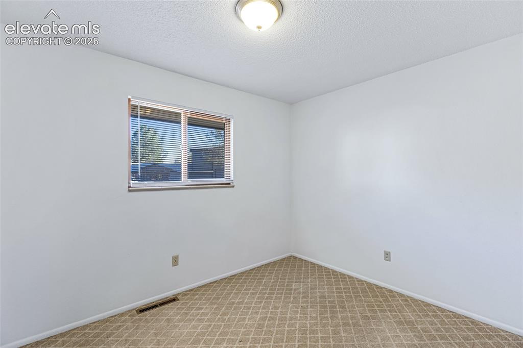 Image 15 of 20: Bright bedroom featuring large casement window with natural light, neutral 