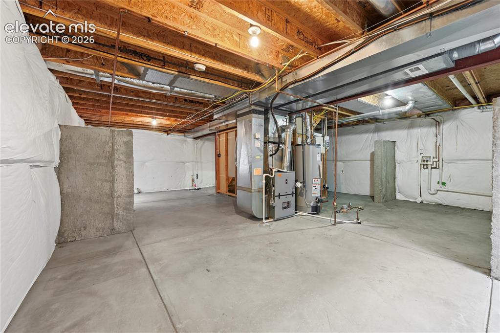 Image 20 of 29: Unfinished basement has laundry hook-ups on the right, a rough-in for a fou