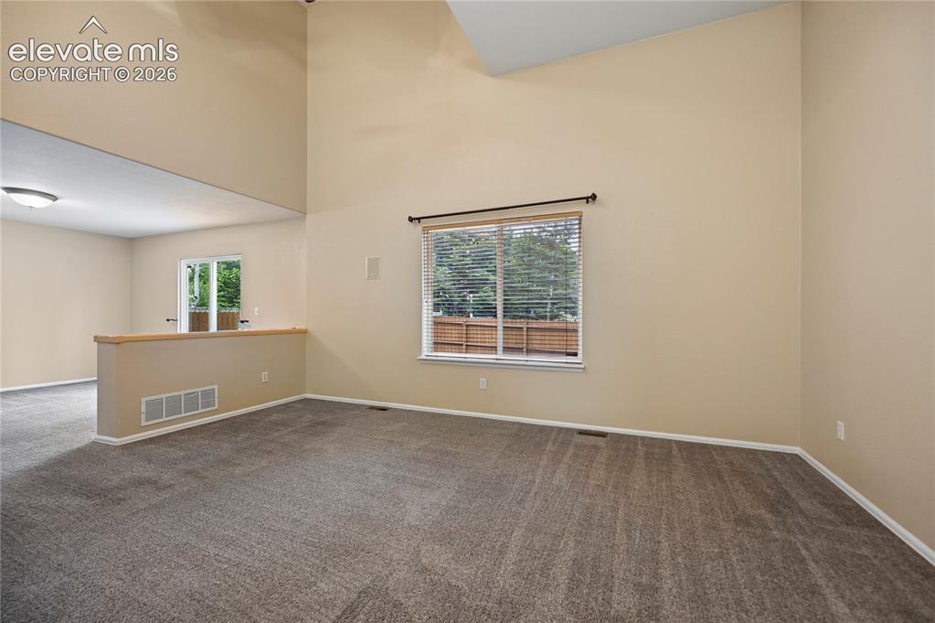 Image 3 of 29: The living room with vaulted ceilings is adjacent to the dining for a wonde