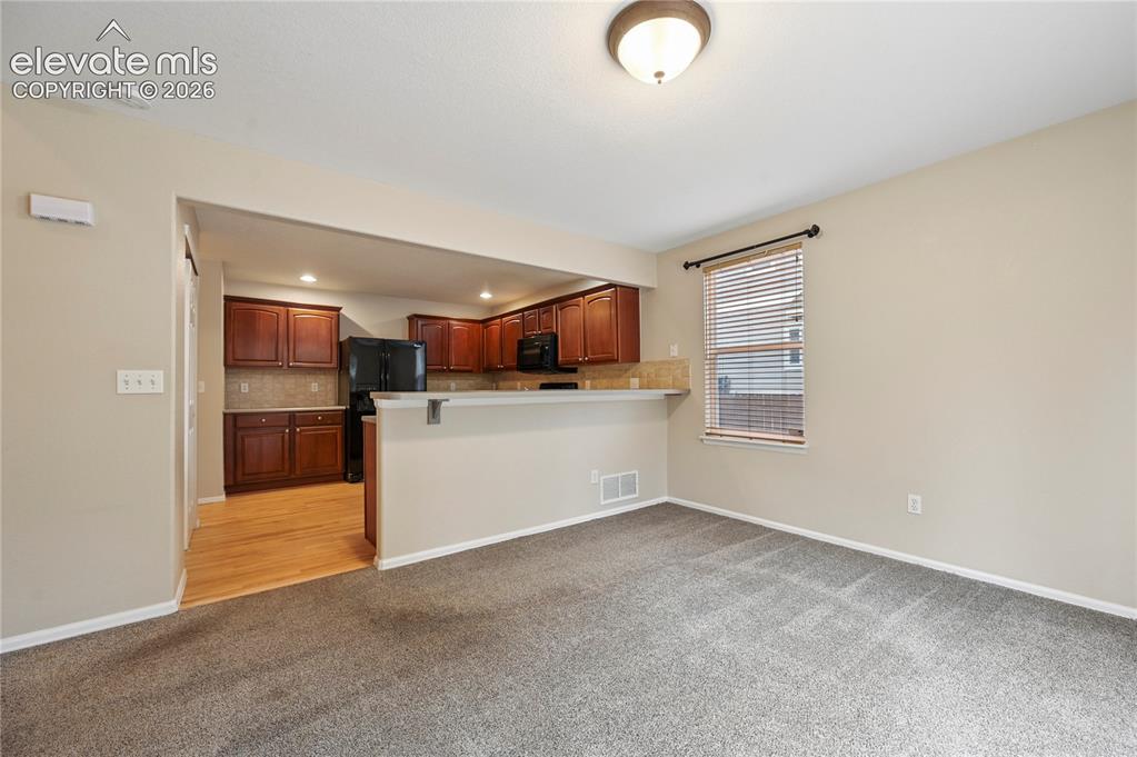 Image 6 of 29: The kitchen & dining room are connected with a peninsular breakfast bar.