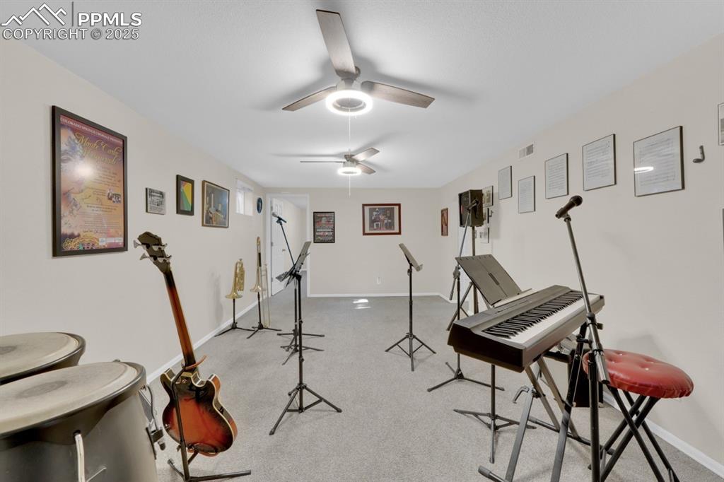 Image 25 of 47: Workout area with ceiling fan and light carpet
