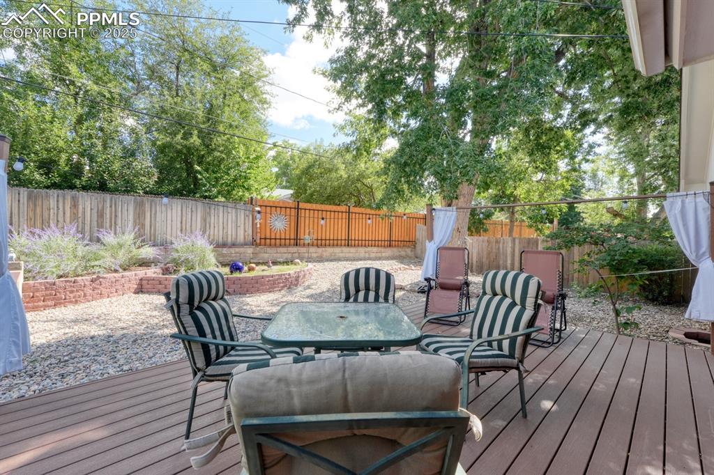 Image 38 of 47: Wooden deck featuring a fenced backyard and outdoor dining space