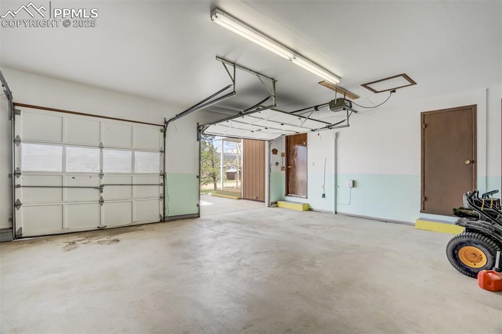 Image 16 of 43: Extended garage with storage closet and door to the sunroom