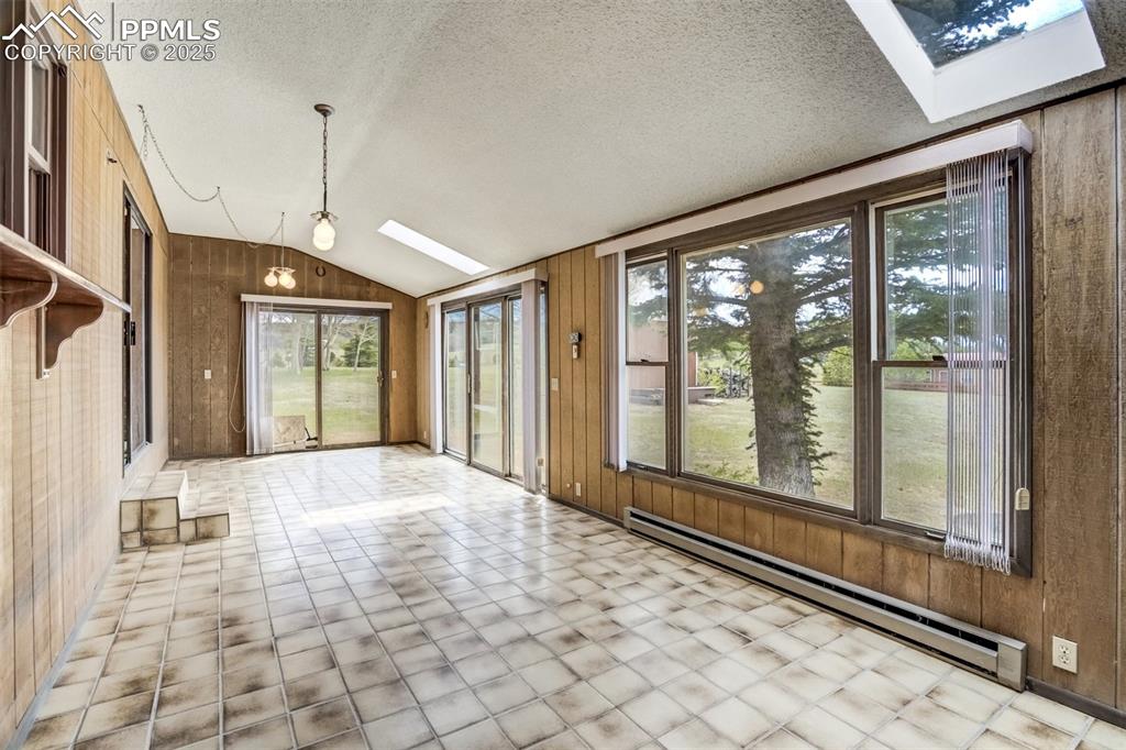 Image 20 of 43: Skylights and sliding glass doors allow for ample light in this extra heate